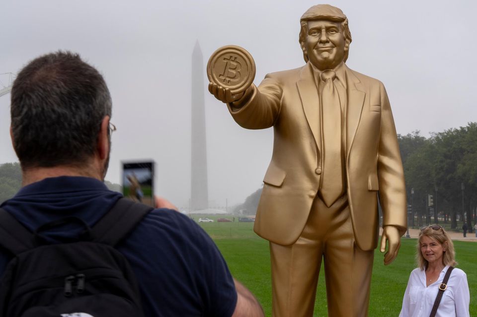 Trump-Statue, die eine Bitcoin-Münze in der Hand hält