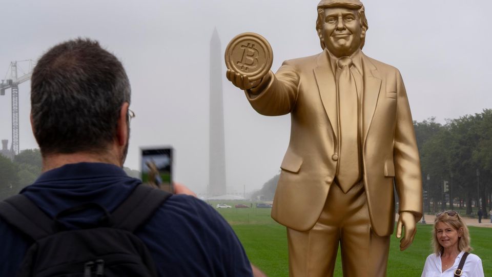 Trump-Statue, die eine Bitcoin-Münze in der Hand hält
