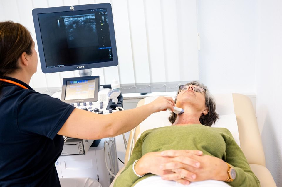 Eine Hausärztin bei der Ultraschalluntersuchung der Schilddrüse