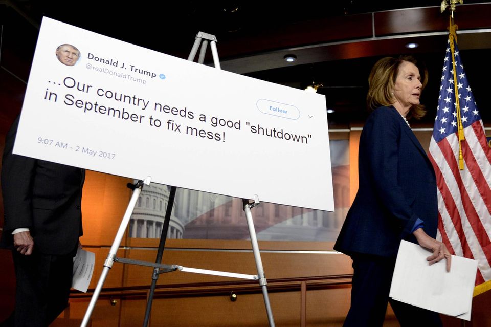 Nancy Pelosi geht an einer Grafik mit einem positiven Zitat von Präsident Trump zum Regierungsstillstand vorbei