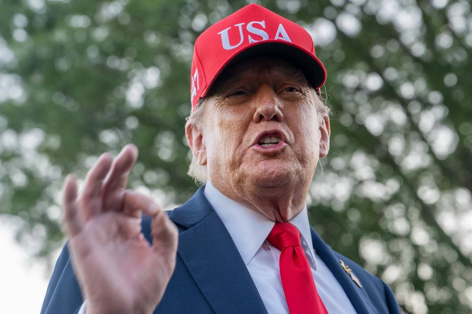 Donald Trump spricht und hat eine USA-Kappe auf dem Kopf