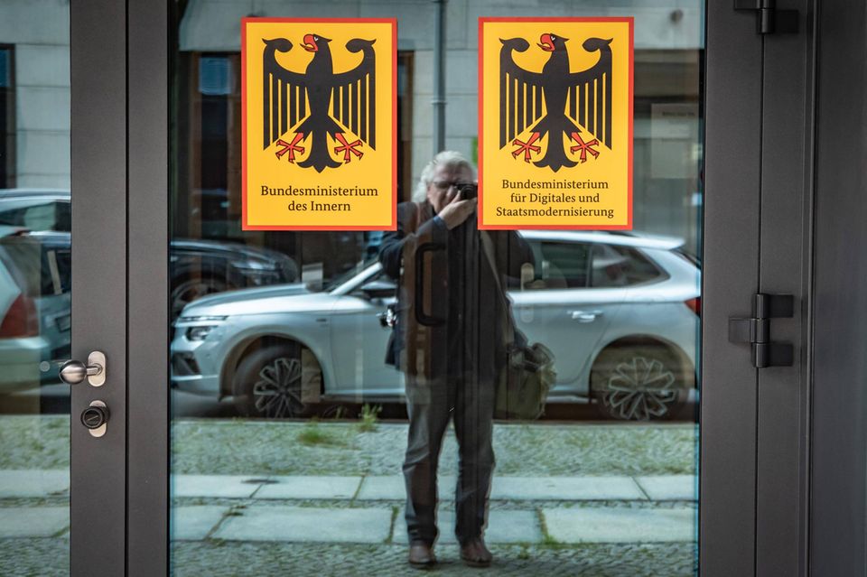 Ein Mann fotografiert den Eingang zum Digitalministerium