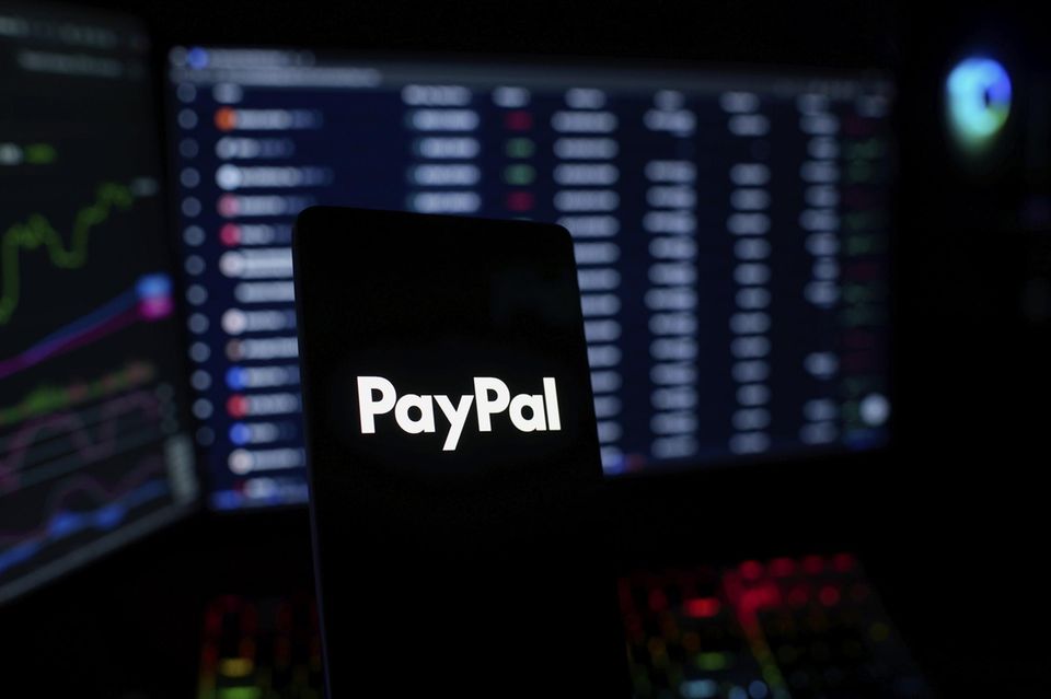 Ein Paypal-Logo vor verschwommenen Bildschirmen