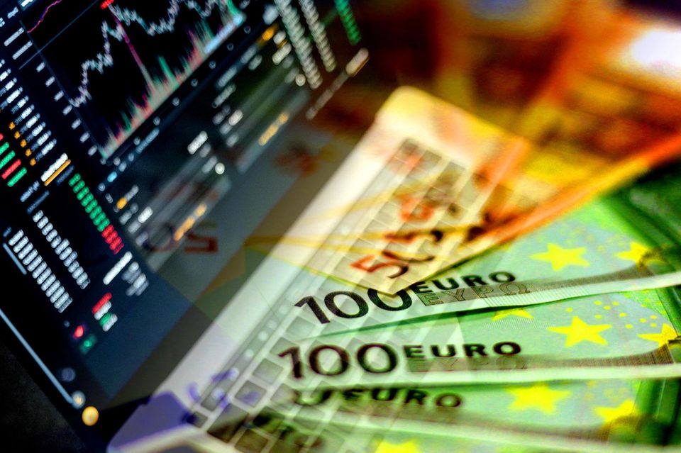 Euro-Banknoten und Notebook mit Börsenindizes