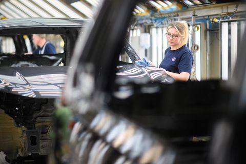 Ein Mitarbeiterin kontrolliert im VW Stammwerk die Lackierung von einem Volkswagen Tayron Ein Mitarbeiterin kontrolliert im VW Stammwerk die Lackierung von einem Volkswagen Tayron