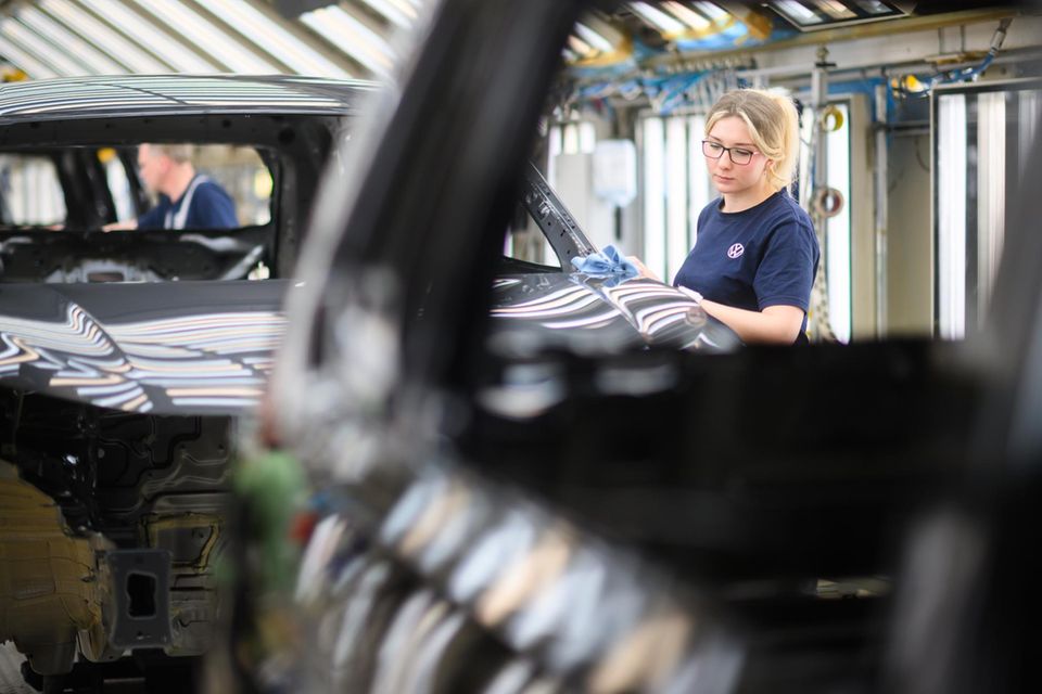 Ein Mitarbeiterin kontrolliert im VW Stammwerk die Lackierung von einem Volkswagen Tayron