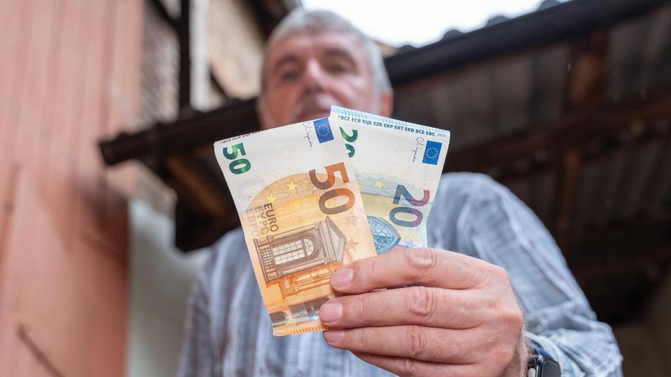 Mann mit Geldscheinen in der Hand