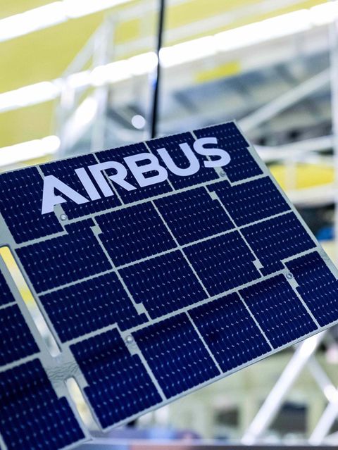 Ein Modell des Europäischen Servicemoduls mit der Aufschrift „Airbus“ steht vor dem ESM-5, an dem Arbeiten stattfinden