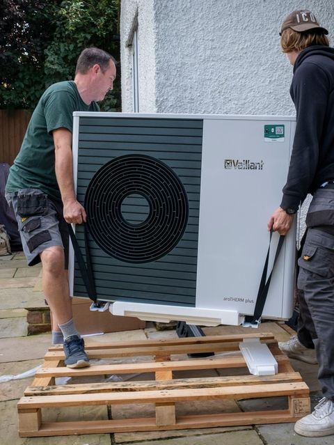 Zwei Männer bauen eine Wärmepumpe ein