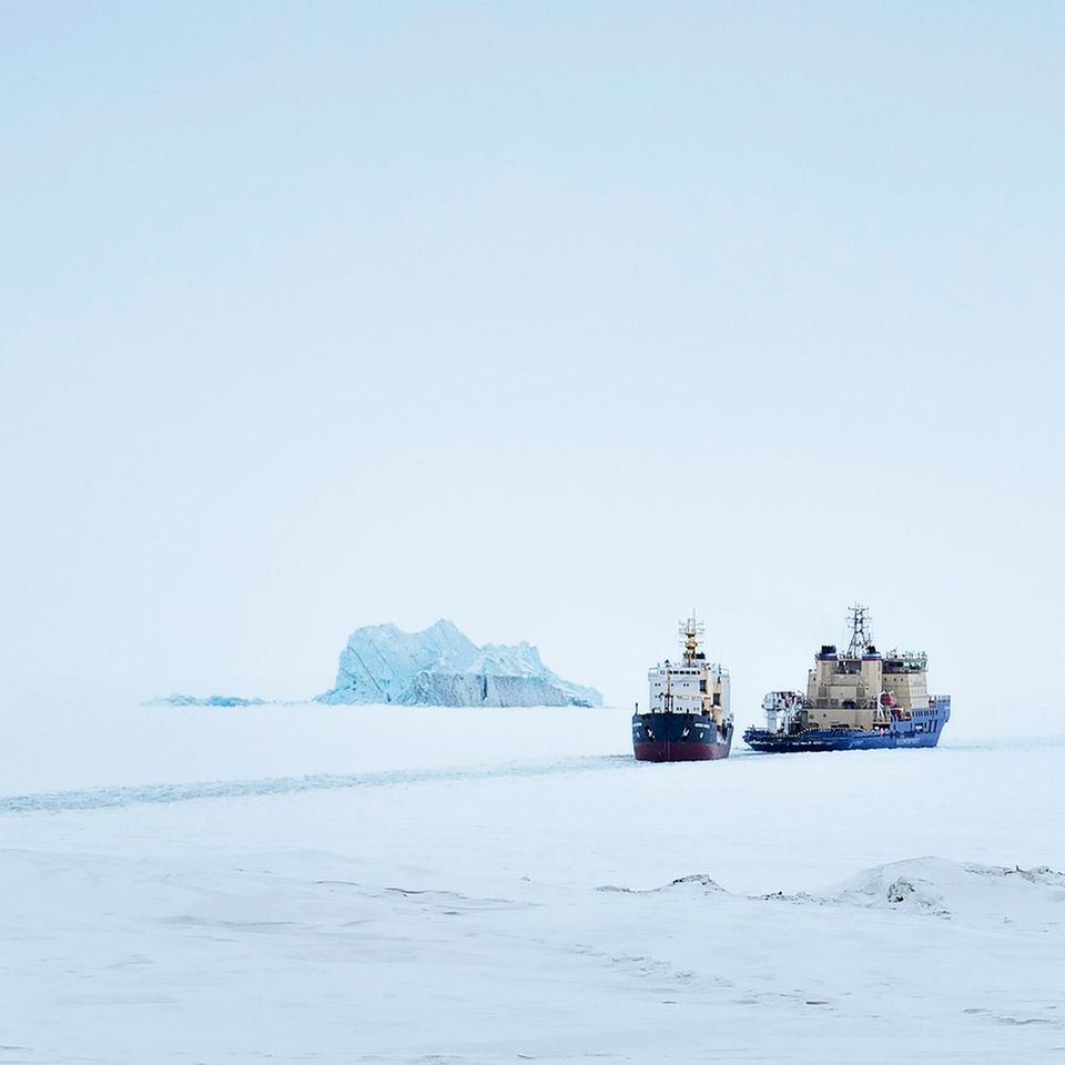 Ein Eisbrecher bahnt den Weg für ein Frachtschiff im Arktischen Ozean
