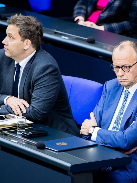 Lars Klingbeil und Friedrich Merz sitzen im Bundestag auf der Regierungsbank