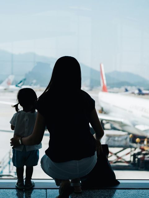 Auswandern mit Familie: Eine Mutter steht mit ihrem Kind am Flughafen