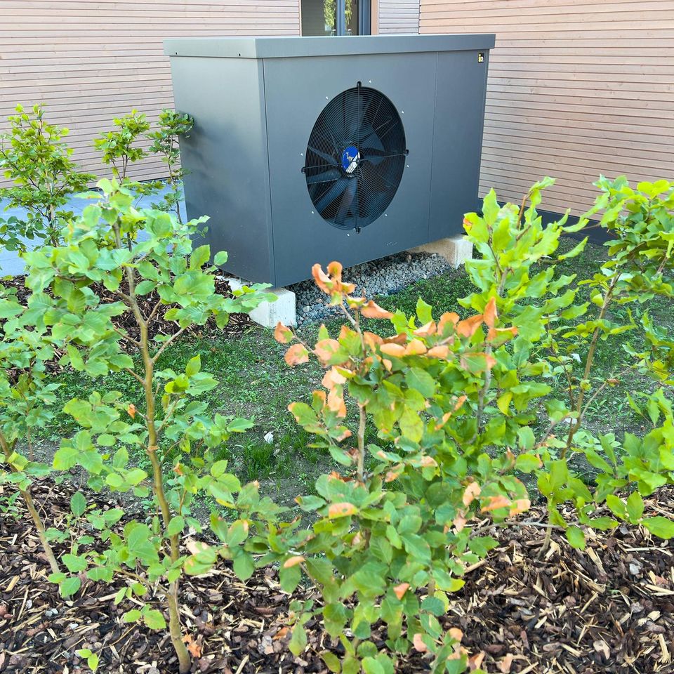 Eine Wärmepumpe steht vor einem Haus