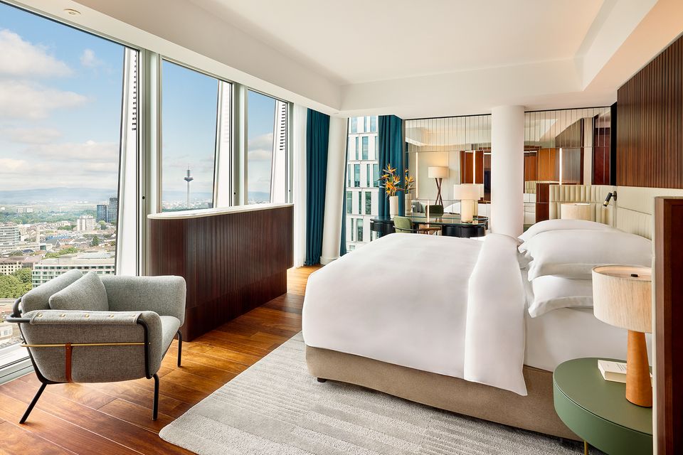 Bodentiefe Fenster holen die Frankfurter Skyline direkt hinein in das exklusive Design der Zimmer und Suiten