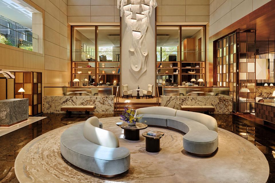 Die neu gestaltete Lobby verbindet eine imposante Raumhöhe mit warmem Holz, Naturstein und elegantem Interior Design