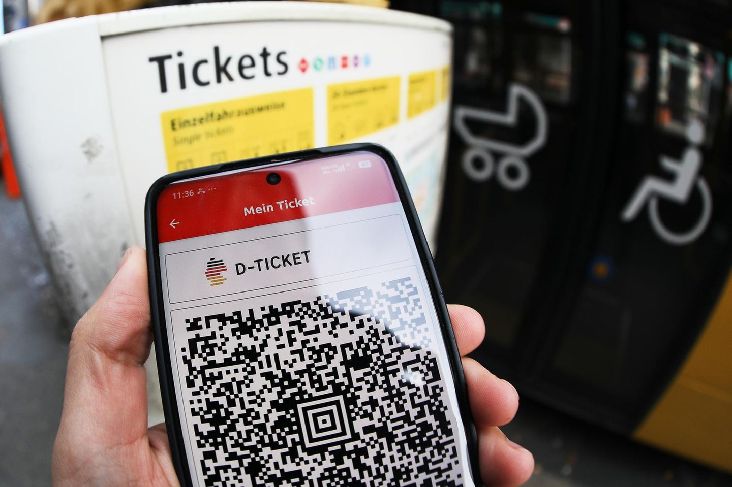 Eine Person hält ein Smartphone mit dem QR-Code für das Deutschlandticket